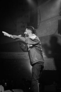 Black and White Photo of Man Performing on Scene